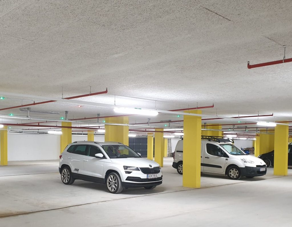 Two parked cars in underground car park equipped with ultrasonic sensors and LED lights from MSR-Traffic