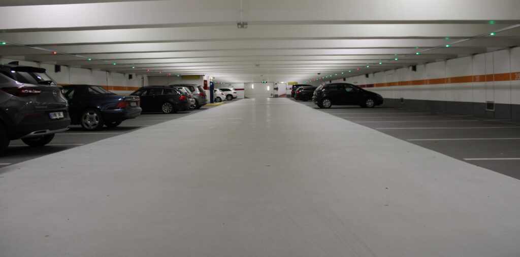 An underground parking garage equipped with SONICI sensors on the ceiling.